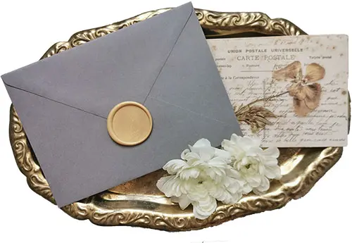 Miniatura stempla do laku okrągłego 30 mm, złote odbicie na szarej kopercie, na zabytkowej złotej tacy z kwiatami.